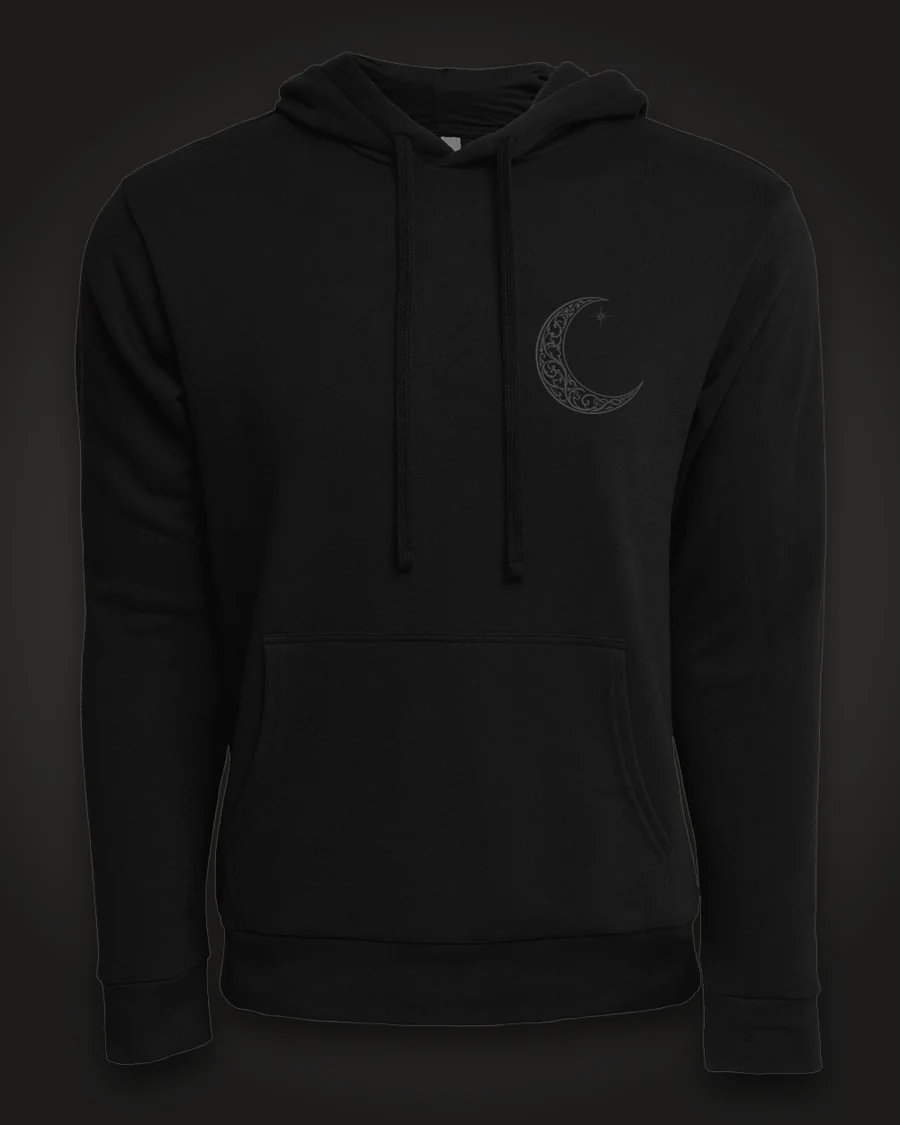 Mockup, front: black hoodie with a small ornate crescent moon on the left chest.