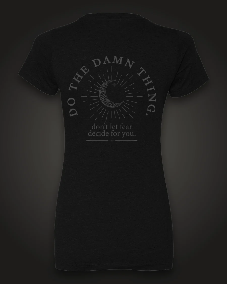 Mockup, back: black women’s tee with a crescent moon in a sunburst, ringed by the words “Do the damn thing.” with “don’t let fear decide for you.” beneath.