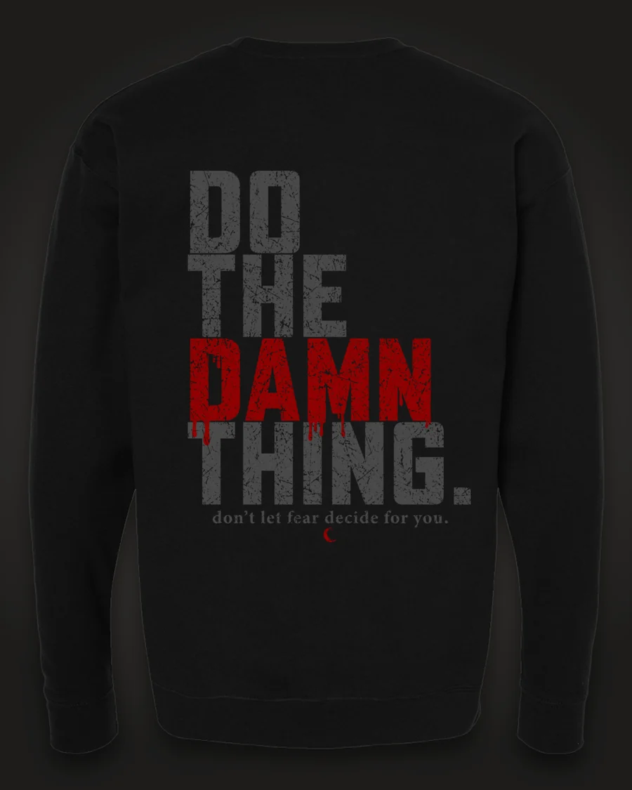 Mockup, back: black crewneck with “Do the damn thing.” in tall distressed grey letters with “Damn” in dripping red, and “don’t let fear decide for you.” beneath.