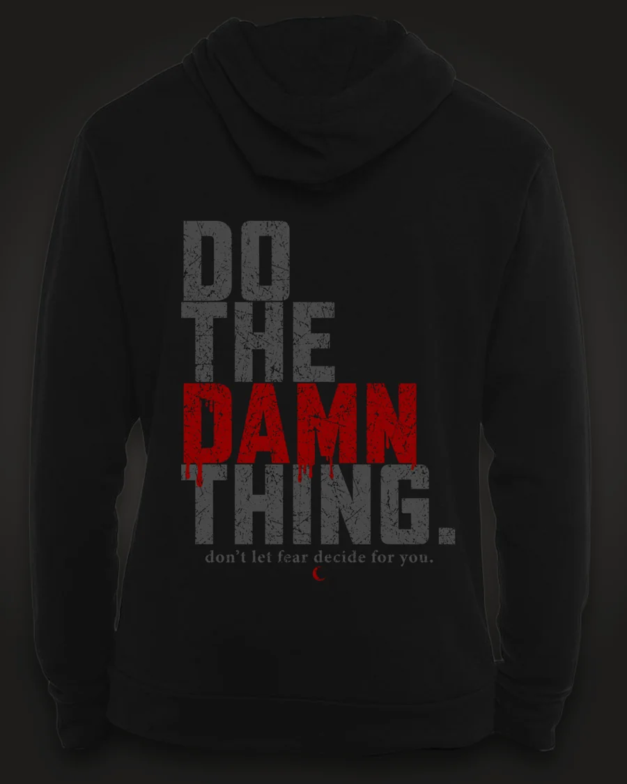Mockup, back: black hoodie with “Do the damn thing.” in tall distressed grey letters with “Damn” in dripping red, and “don’t let fear decide for you.” beneath.